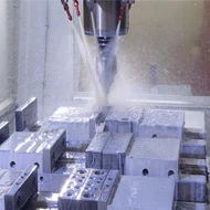 CNC machine cutting and shaping a metal component