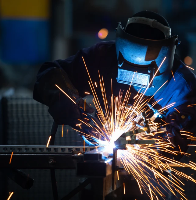 Technician welding metal assembly at LMI shop floor