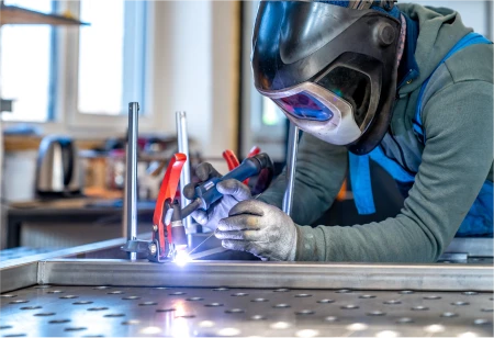 Technician welding metal assembly at LMI shop floor