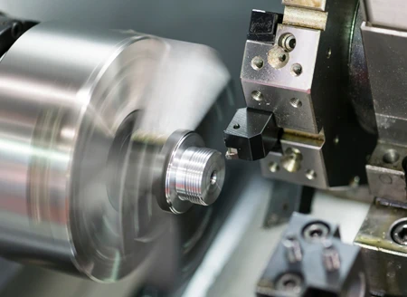CNC machine cutting and shaping a metal component