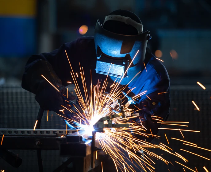 welder with full gear and sparks flying