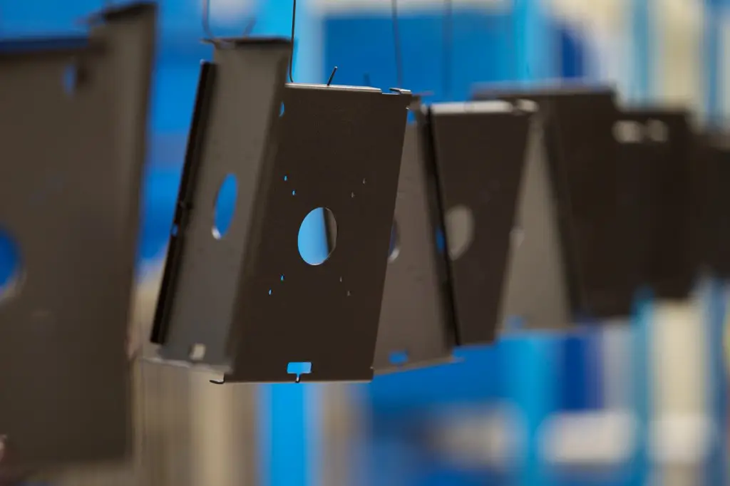 Powder coating and finishing on manufactured metal part
