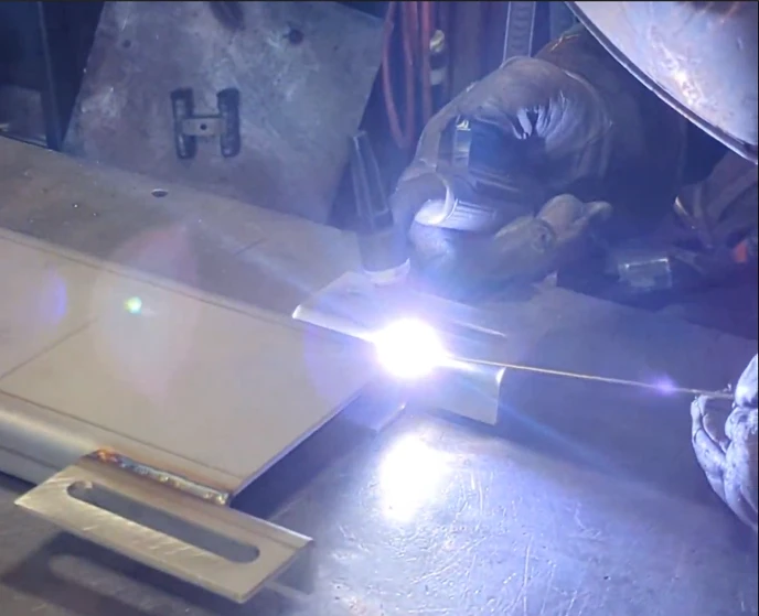 Technician welding metal assembly at LMI shop floor